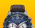 A Citizen Racing Chronograph CA4716-09L közelképe, amelyen látható a kék tachyméter keret, a mélykék számlap ezüstszínű mutatókkal és jelölésekkel, a három kis számlap, a piros központi másodpercmutató, valamint a barna, perforált bőr szíj sárga háttér előtt.