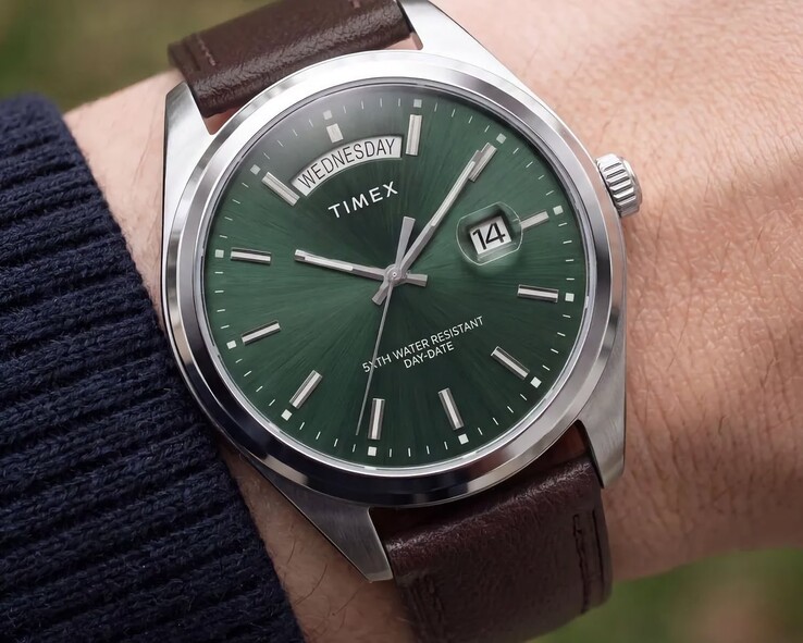 A Timex Legacy Day and Date egy csuklón, zöld, napsugármintás számlappal.