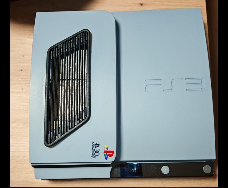 Az egyedi matt ezüstszürke PS3 Slim Pro felülnézetben, fekete ékezetekkel, szellőzőráccsal és a 30. évfordulós PlayStation-logóval a tokon. (Kép forrása: Fun-Equivalent-7785 via Reddit / r/PS3)