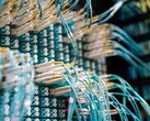 Kék száloptikai kábelek fehér csatlakozókkal, amelyek egy adatközpont patch paneljébe vannak dugva