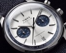 Közeli kép a Timex Marlin Jet Chronograph TW2Y89900 óráról, amelyen látható az ezüstfehér számlap, a sötétkék segédszámlapok, a rátett óraindexek, a pálcamutatók, a tachiméterskála és a dátumablak.