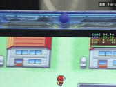 Közeli kép az átlátszó kék FPGBA SP kézikonzolról, amelyen a Pokémon fut, és egy 59,74 FPS-t mutató számláló látható.