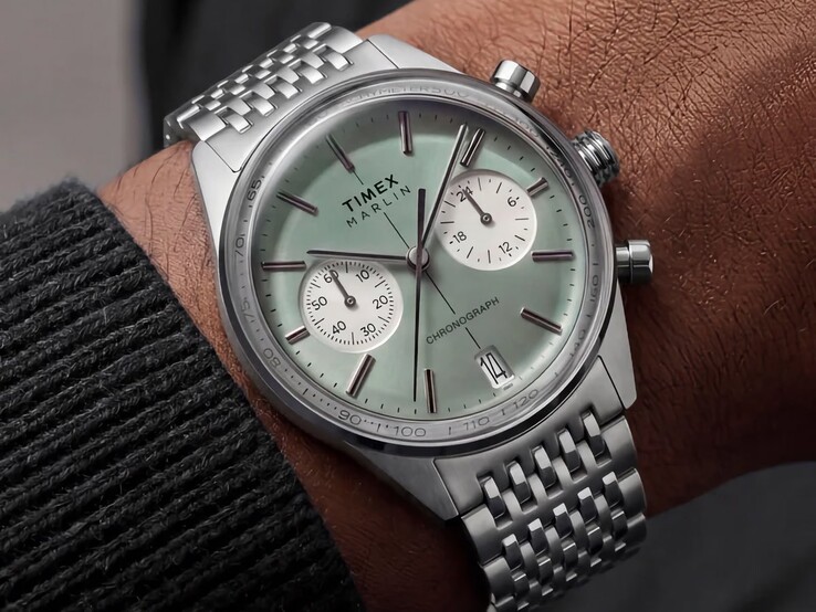 A Timex Marlin Jet Chronograph, zsályazöld számlappal és rozsdamentes acél karkötővel, csuklón viselve, domború üvegével és lekerekített, retro-futurisztikus tokprofiljával.