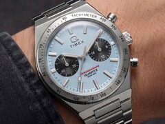 Közelkép a csuklón viselt Timex Q Timex Continental Chronograph TW2Y92400 óráról, amely jégkék, sugárirányú CD-stílusú számlappal, fekete kis számlapokkal, ezüst tachyméter kerettel és integrált rozsdamentes acél karkötővel rendelkezik.