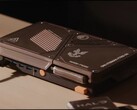 Egy egyedi gyártású, kompakt játékkonzol, amely mini PC-vel, látható hűtőnyílásokkal, USB-portokkal és narancssárga bekapcsológombokkal rendelkezik, az asztalon.