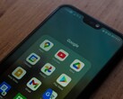 Okostelefon egy fa íróasztalon, megnyitott Google-alkalmazásmappával