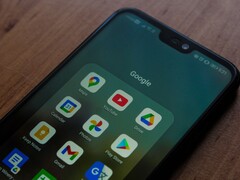 Okostelefon egy fa íróasztalon, megnyitott Google-alkalmazásmappával