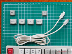 Extra billentyűsapkák a macOS és Windows felhasználók számára, valamint egy hosszú, fonott USB C-C kábel.