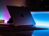 Félnyitott MacBook egy sötét szobában, a résből fény szűrődik az asztalra