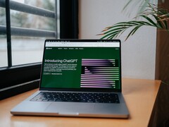 Laptop egy ablak melletti asztalon, a képernyőn az OpenAI ChatGPT weboldala látható