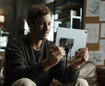 A felhasználó a Sharge Disk Pro átlátszó, aktív hűtéssel ellátott hordozható SSD-t USB-C kábelen keresztül csatlakoztatja egy táblagéphez. (Sharge a Kickstarteren keresztül)