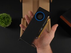 Egy személy kezében az Intel Arc Pro B50 alacsony profilú, fúvóstílusú hűtővel ellátott munkaállomási GPU, a csomagoló dobozával szemben. (Kép forrása: ETA Prime via YouTube)