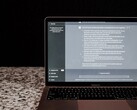Egy laptop, amelyen sötét háttér előtt egy mesterséges intelligencia-csevegőablak látható; stockfotó, amely a felhő nélküli, helyszíni mesterséges intelligenciát ábrázolja.