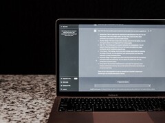 Egy laptop, amelyen sötét háttér előtt egy mesterséges intelligencia-csevegőablak látható; stockfotó, amely a felhő nélküli, helyszíni mesterséges intelligenciát ábrázolja.