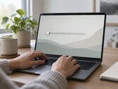 Kezek egy laptop billentyűzetén, a képernyő bal szélén egy csúszka