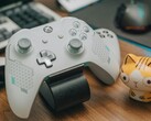Fehér Xbox kontroller egy fa asztalon egy kis macskafigura mellett (Kép forrása: FOX ^.ᆽ.^= ∫ via Pexels)