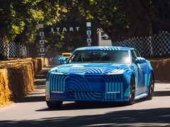 A „Blue Exuberant Modernism Camouflage” színű Jaguar Type 01 EV száguld el a Goodwood Hill Climb rajtrácsa mellett