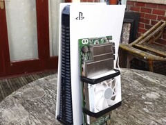 Egy PlayStation 5 konzol egy egyedi építésű AMD BC250 lapka mellett, amelyre hűtőbordát és hűtőventilátort szereltek. (Kép forrása: Budget-Builds Official via YouTube)